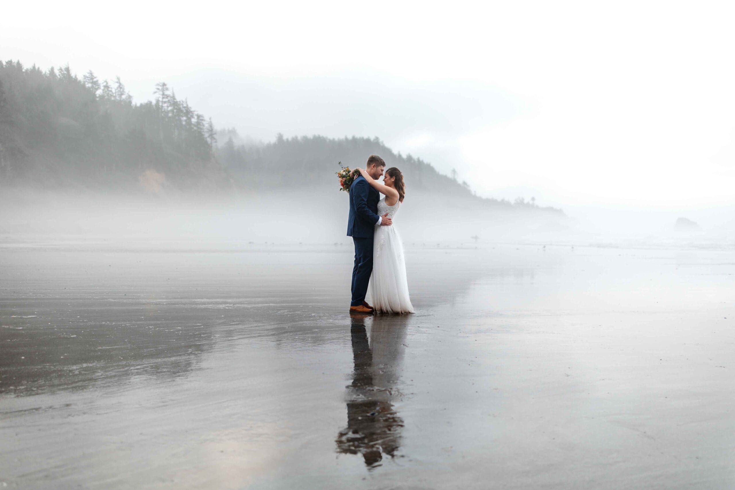 a wedding couple embrace on indian beach at ecola state park in oregon